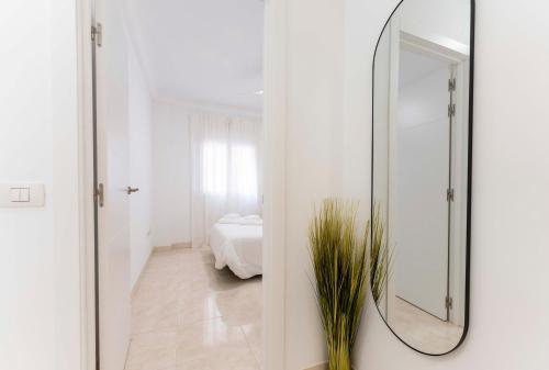 a mirror in a white room with a bedroom at La Casita del Muelle 50 m Sea-Apartamento cerca Aeropuerto Tenerife Sur-Los Abrigos in Los Abrigos