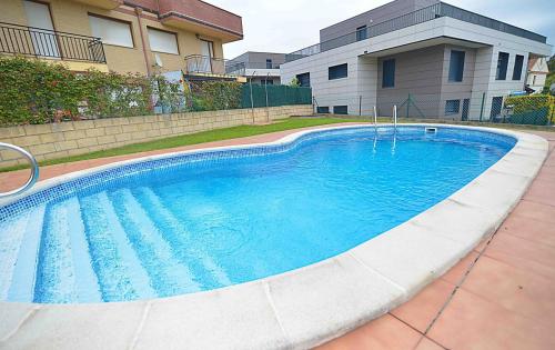 a large blue swimming pool in front of a building at El apartartamento de Santa Eva by Just Room in Miengo
