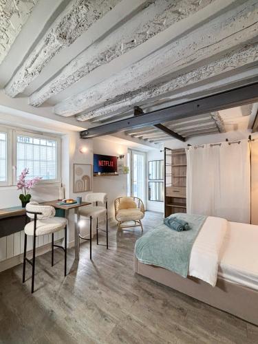a bedroom with a bed and a table and chairs at Studio Cosy Paris Centre République Marais in Paris