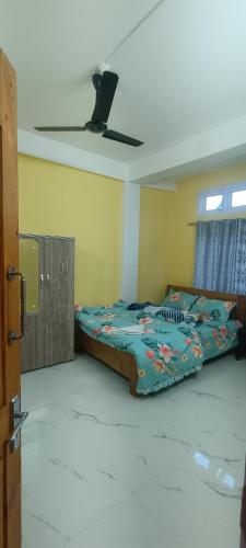 a bedroom with two beds and a ceiling at Green Tara Homestay in Dirang Dzong