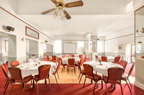 a dining room with tables and chairs and a projection screen at The County Hotel in Carlisle