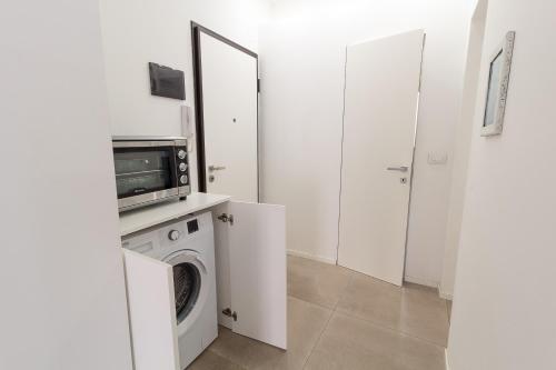 a laundry room with a washing machine and a microwave at LA PERLA in Cefalù