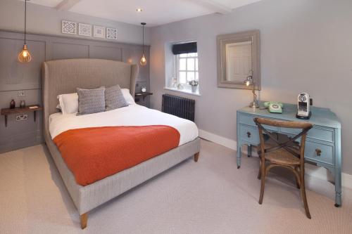 a bedroom with a bed and a table and a chair at The George Townhouse in Shipston on Stour
