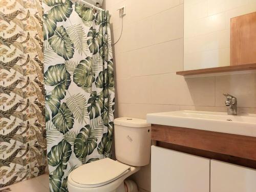 a bathroom with a toilet and a sink and a shower curtain at Family airport relax apartment in Deroua