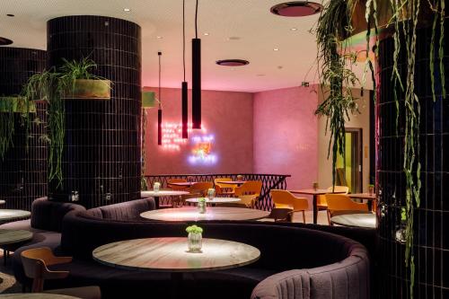 a restaurant with purple walls and tables and chairs at Hotel Hotel - Member of Design Hotels in Lisbon