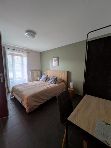 a bedroom with a large bed and a table at L'Estampille in Saint-Vidal