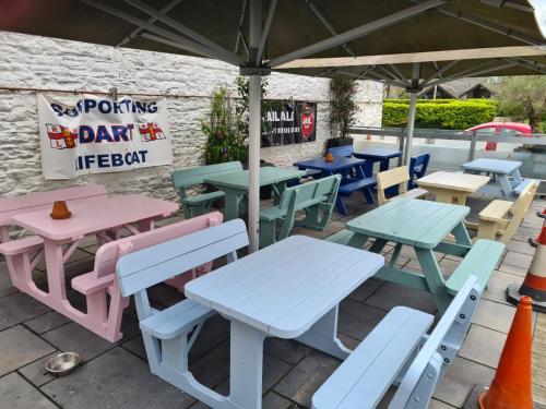 a group of picnic tables and chairs under a tent at George & Dragon in Dartmouth