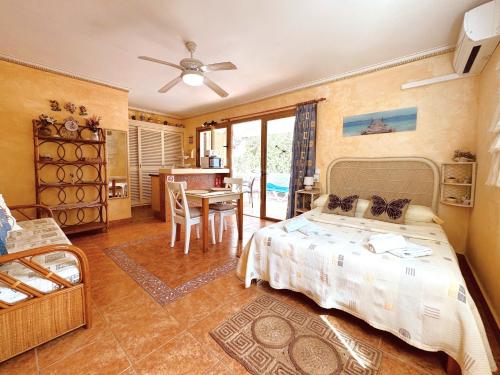 Un dormitorio con una cama y una mesa y una cocina. en Eguzkilore, en Es Pujols