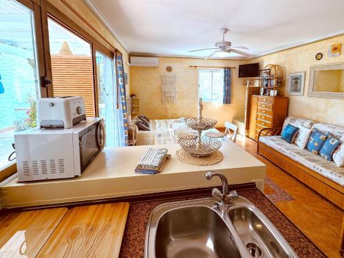 una cocina con fregadero y microondas en Eguzkilore, en Es Pujols