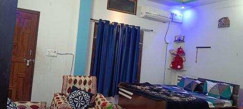 a room with a bed and a blue curtain at kanak homestay in Ayodhya
