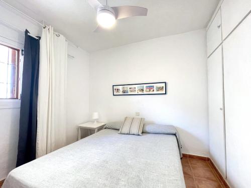a small bedroom with a bed and a window at Edificio Rex I ES.01 2ª PT.04 in Es Pujols