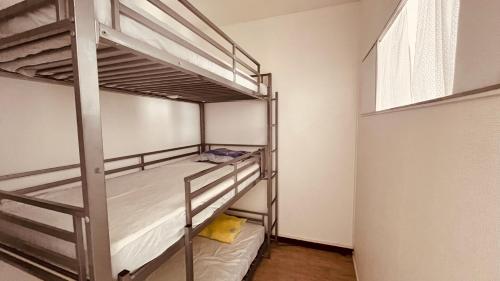 une chambre avec deux lits superposés et une fenêtre dans l'établissement Appart des Tamaris, 200m de la plage, à Saint-Jean-de-Monts