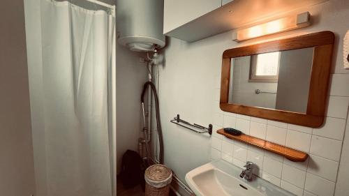 une salle de bain avec un lavabo et un miroir dans l'établissement Appart des Tamaris, 200m de la plage, à Saint-Jean-de-Monts