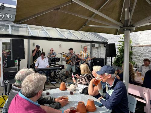 a group of people sitting around a table playing music at George & Dragon in Dartmouth