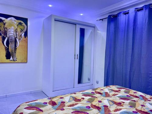 a bedroom with an elephant picture and a bed at Charming and peaceful F3 House in Dakar