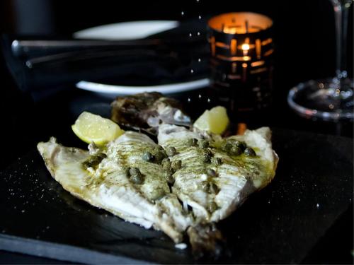 a plate of food with fish and lemon slices at OTL Gouverneur Sherbrooke in Sherbrooke