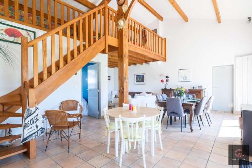 Cette chambre dispose d'un escalier en bois, de tables et de chaises. dans l'établissement Maison de vacance avec jardin 8 personnes Biscarrosse, à Biscarrosse
