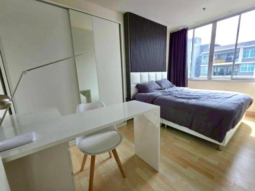 a bedroom with a bed and a desk with a bed and a bed petertodd at Cozy bed with WiFi Pool Gym in Udon in Udon Thani