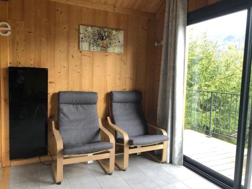two chairs sitting on a porch next to a balcony at Clos Shambhala-Chalet d'hôtes in Saint-Jean-Saint-Nicolas