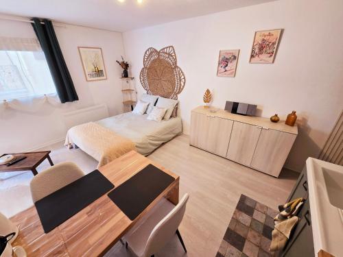 un salon avec une table et un lit dans l'établissement Studio cosy, à Bagnères-de-Bigorre