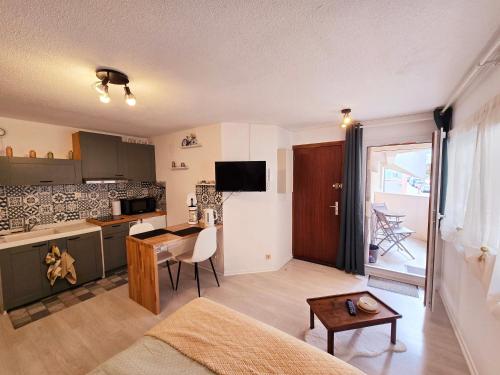 une chambre avec une cuisine et un salon avec une table dans l'établissement Studio cosy, à Bagnères-de-Bigorre