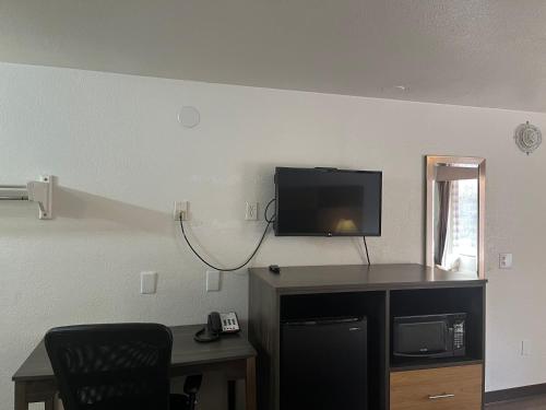 a room with a desk and a tv on a wall at Motel 6 Cross Lanes, WV Goff Mountain Rd in Cross Lanes