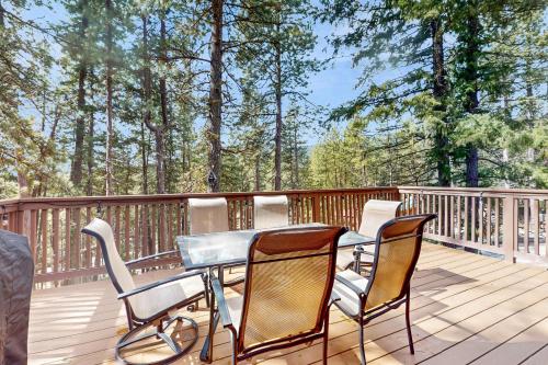 a table and chairs on a deck with trees at Copper Top Ski Chalet in Leavenworth