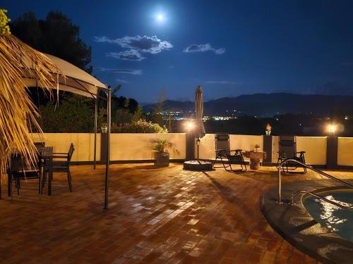 a patio with a table and chairs at night at B&B Finca la Yuca "Un paraíso en Ontinyent" in Ontinyent