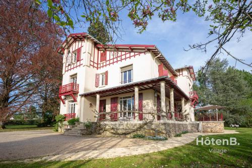 una grande casa con finiture rosse e bianche di Maison Léonce Blanc - Prestige in Lubersac a Lubersac