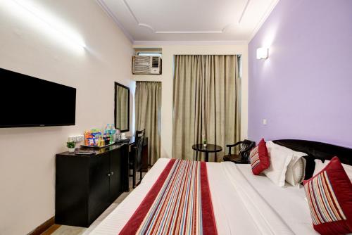 a hotel room with a bed and a flat screen tv at Hotel City Centre Inn Near Nizamuddin Railway Station in New Delhi