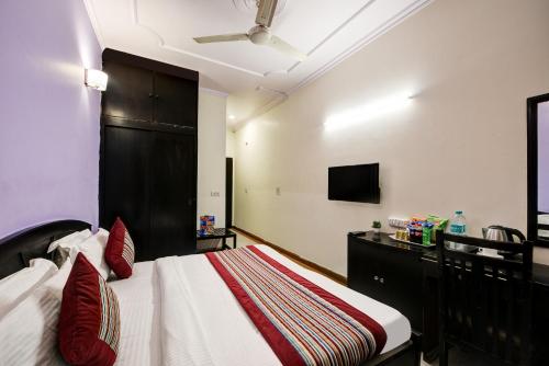 a bedroom with a bed and a tv on the wall at Hotel City Centre Inn Near Nizamuddin Railway Station in New Delhi