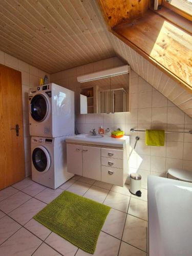 a kitchen with a washing machine and a sink at Apartment Simcha in Niederwichtrach