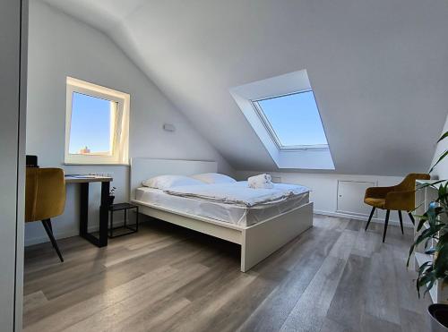 a bedroom with a bed and a desk and a window at Modernes Apartment Melia in Hamm