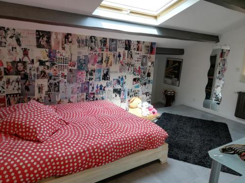 - une chambre avec un lit rouge et un mur de photos dans l'établissement La Parenthèse, à La Seyne-sur-Mer