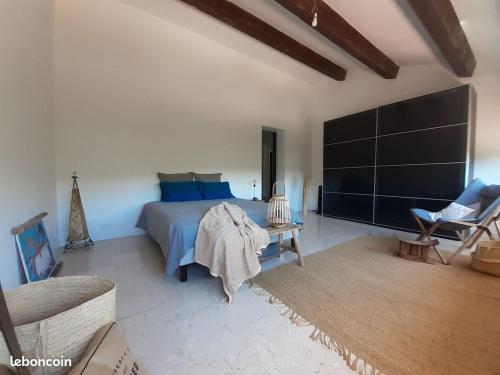 - une chambre avec un lit bleu et une table dans l'établissement La Parenthèse, à La Seyne-sur-Mer