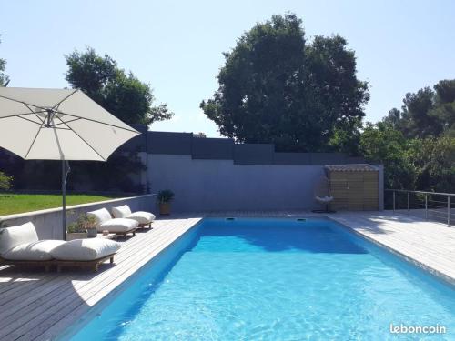une piscine avec des chaises longues et un parasol dans l'établissement La Parenthèse, à La Seyne-sur-Mer