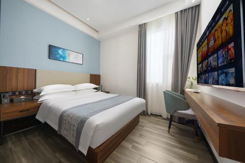 Una habitación de hotel con una cama grande y un escritorio. en Canton Isle Hotel, en Guangzhou