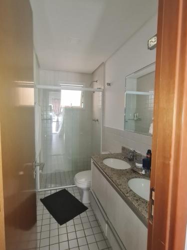 ein weißes Badezimmer mit zwei Waschbecken und einer Toilette in der Unterkunft L23 apartamento alto padrão-Itagua in Ubatuba