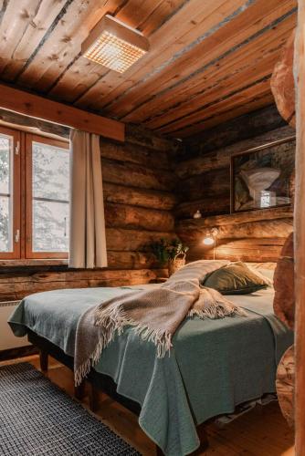 a bedroom with a bed in a log cabin at Rukanhohde in Ruka