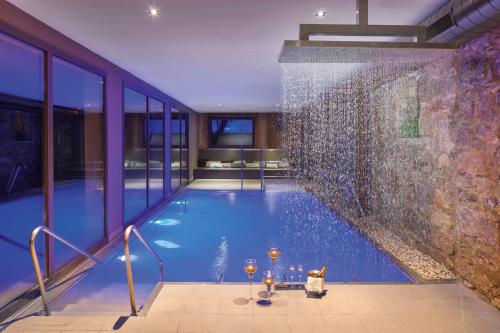 a large swimming pool in a building with glass walls at Hotel-Balneari Sant Vicenç in El Pont de Bar