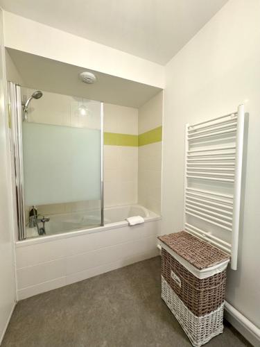 une salle de bain blanche avec une baignoire et une douche dans l'établissement Chez Jules, Rennes centre, à Rennes