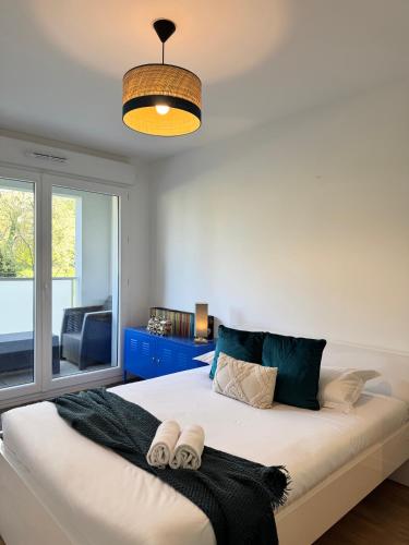 une chambre avec un grand lit avec deux serviettes dessus dans l'établissement Chez Jules, Rennes centre, à Rennes