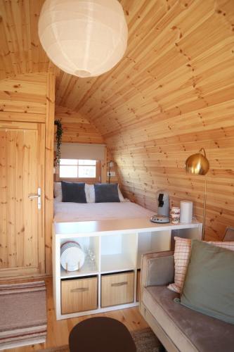 a small room with a bed and a couch at Huisje Vigga - knus houten tiny house in Anloo