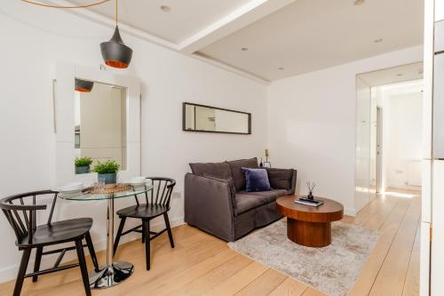 a living room with a couch and a table at Soho by Excel Apartments in London