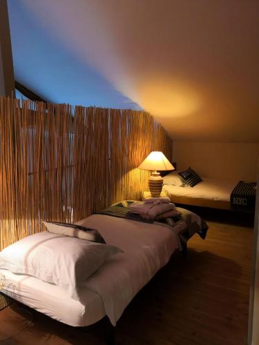 une chambre d'hôtel avec 2 lits et une lampe sur le lit dans l'établissement Gite du Hameau D'Amignié, à Vernay