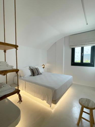 a white bedroom with a bed and a window at Faros Residences in Faros