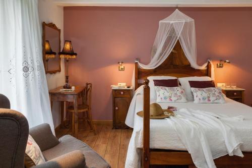 a bedroom with a canopy bed with a hat on it at Hotel-Balneari Sant Vicenç in El Pont de Bar