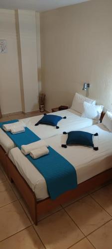 two large beds in a room with blue pillows at Rodica Studios in Kallithea Halkidikis