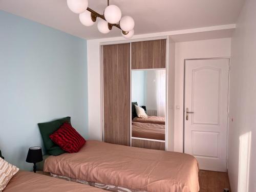 une chambre avec deux lits et un miroir dans l'établissement Home in Paris! sun, free parking, garden!, à Villejuif