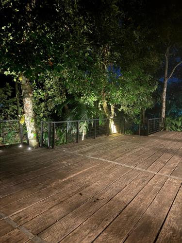 a wooden deck with a fence and trees at night at Water Pearl in Kosgama